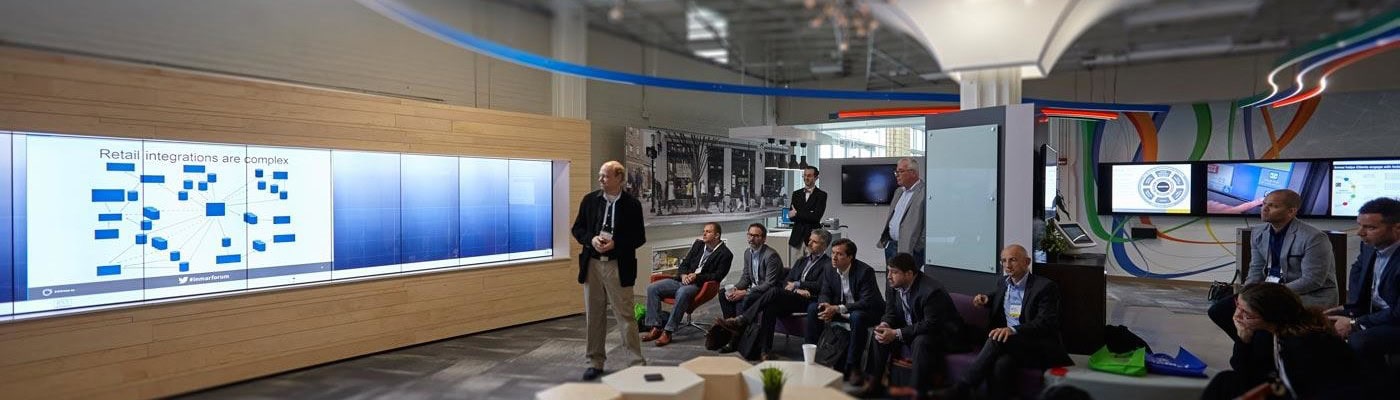 Presentation in conference room with organic shape table and wall of monitors