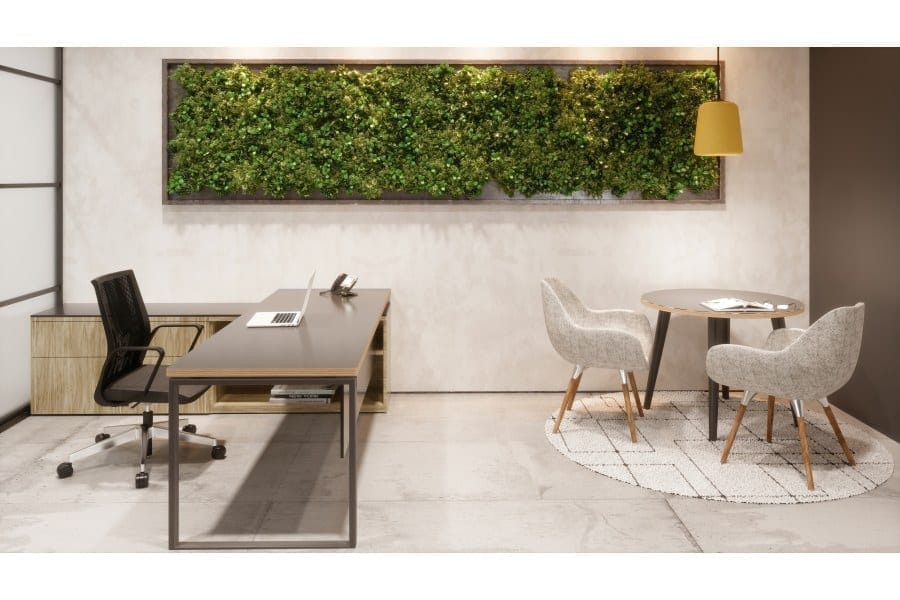 Contemporary office space with modern furniture and a lush green wall for engaging corporate events.