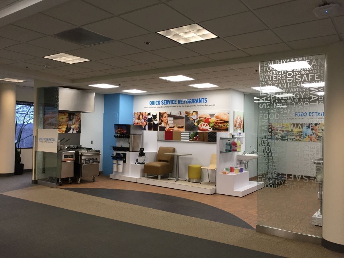 Ecolab Tour Stop custom interior with fabricated risers, kiosks, product displays, wall graphics and glass vinyl lettering