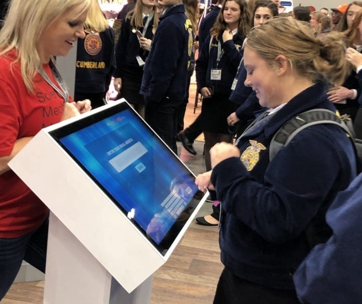 FMC trade show touch screen kiosk with staffer and attendee