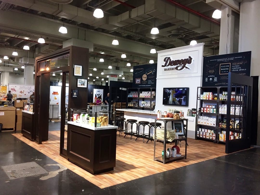 Deweys Bakery food trade show exhibit with product displays and comfort seating