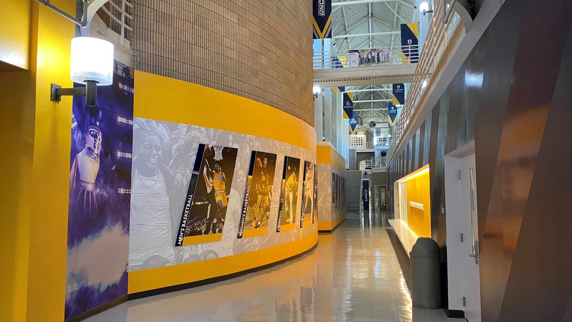 Bright indoor sports exhibit with basketball-themed wall art and memorabilia at Holt Experiential.