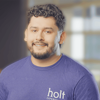 Engaged team member at Holt Experiential smiling confidently indoors.