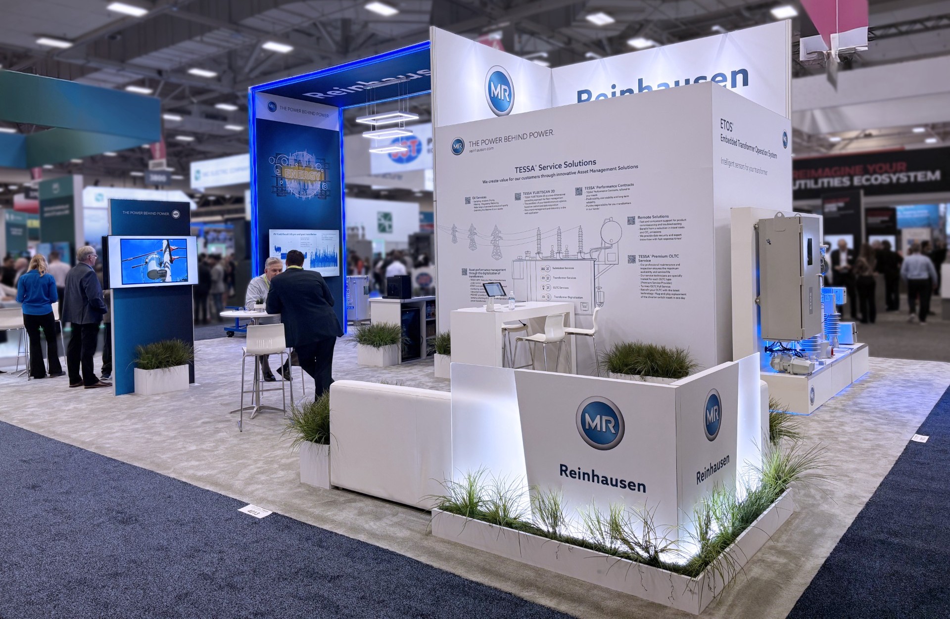 Modern trade show booth for Holt Experiential showcasing innovative energy and asset management solutions at a busy industry exhibition.