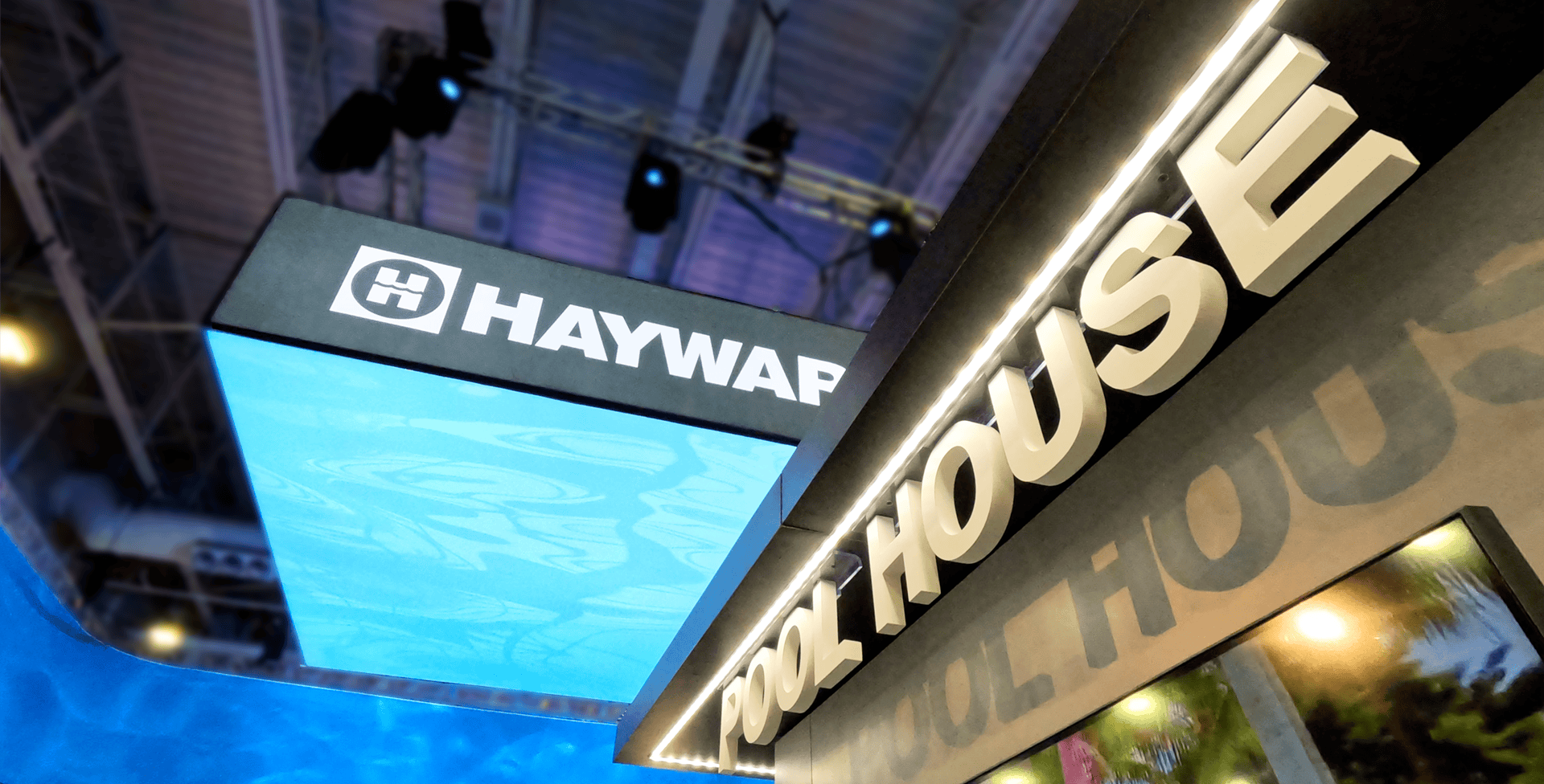 3D branded signage highlighting the Hayward Pools exhibit&rsquo;s pool house, featuring hospitality areas for food and drinks and a hidden conference room for executive meetings, designed by Holt Experiential.