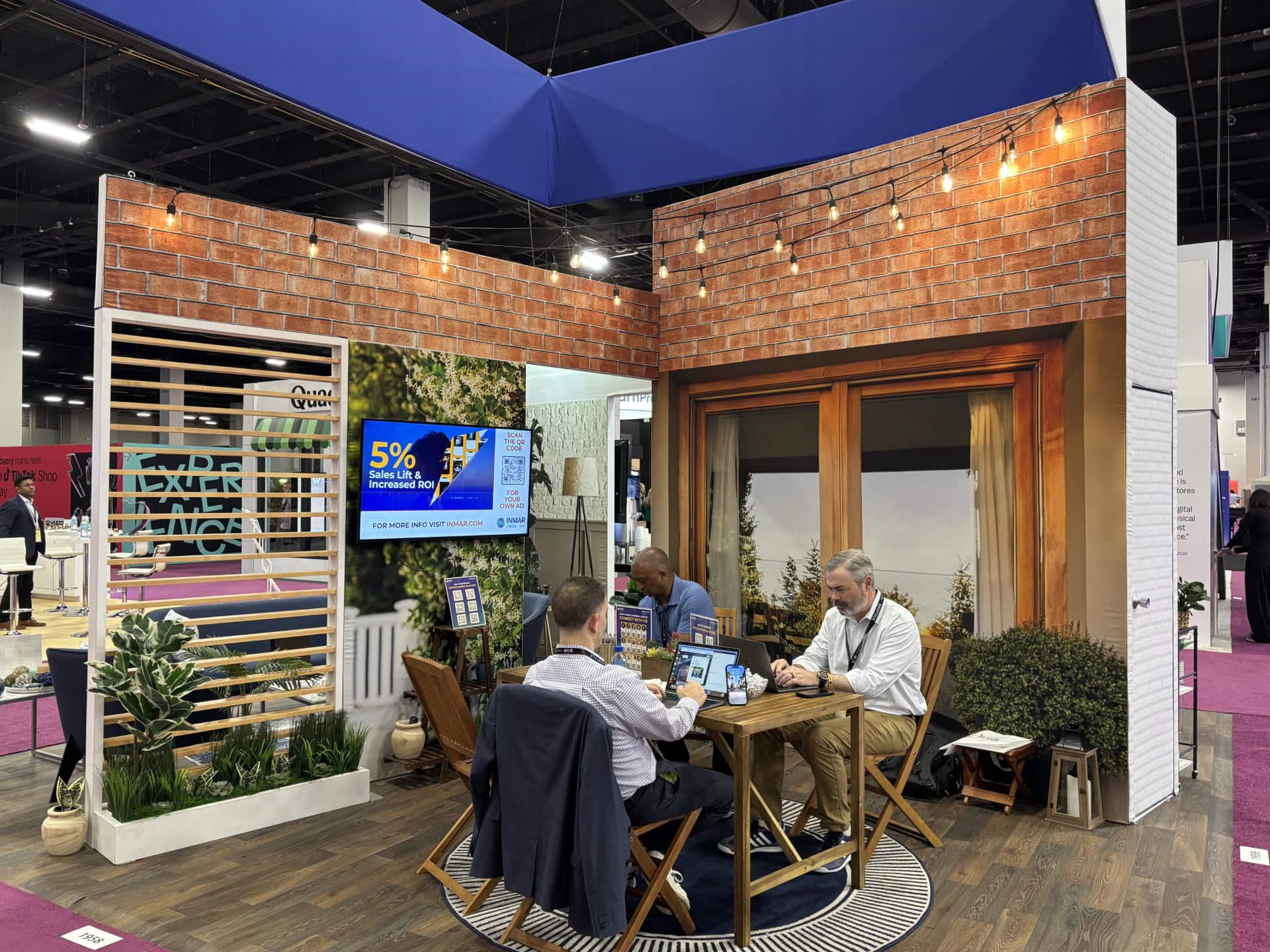 Modern office booth with brick walls, wooden accents, and outdoor view, showcasing Holt Experiential's innovative event spaces.