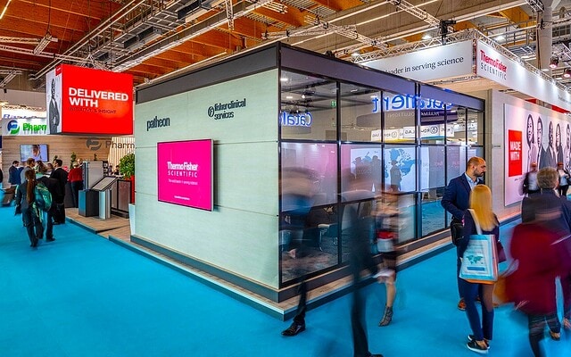 Innovative trade show booth by Holt Experiential with interactive digital displays and vibrant branding.