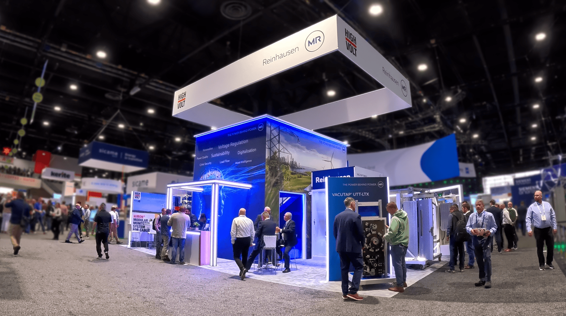 Wide view of Reinhausen's custom two-story exhibit at IEEE 2026 in Chicago with visitors exploring products and meeting with the sales team.