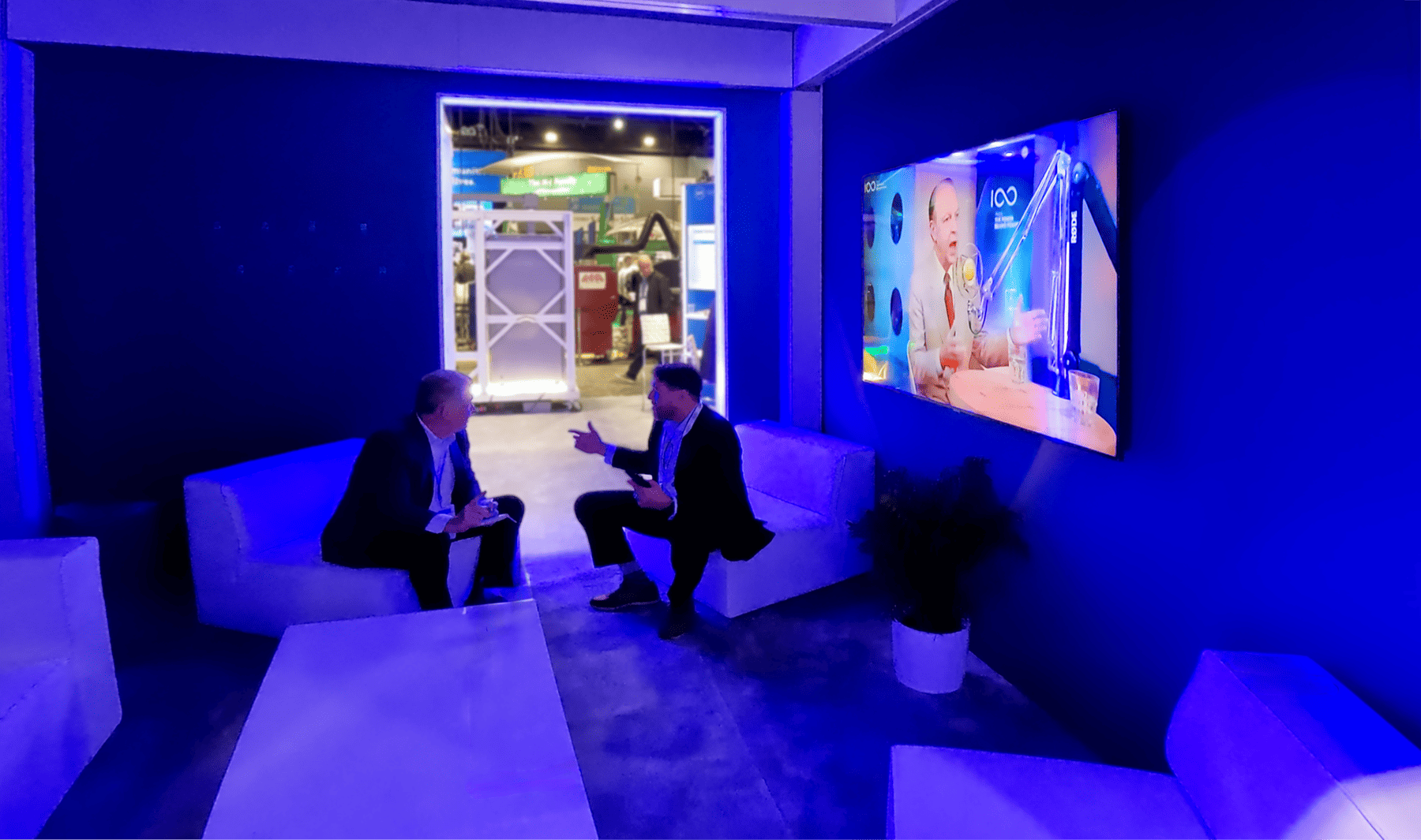 Semi-private meeting lounge in the Reinhausen exhibit featuring comfortable seating and a video presentation celebrating the 100-year history of the resistor tap-changer.